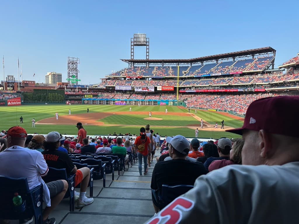 A baseball game view from seats in the shade on a sunny summer evening in Philadelphia, Pennsylvania.